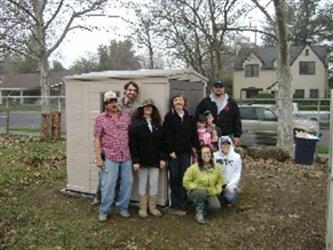 Faculty members in front of a shed